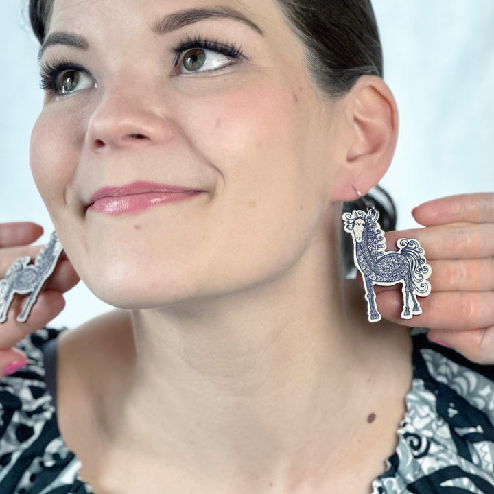 Virkkukoukkusen hauskat kotimaisesta koivuvanerista valmistetut Polleena-korvakorut, joissa heiluu ihanat mustavalkoiset hepat. Koukkukiinnitys.